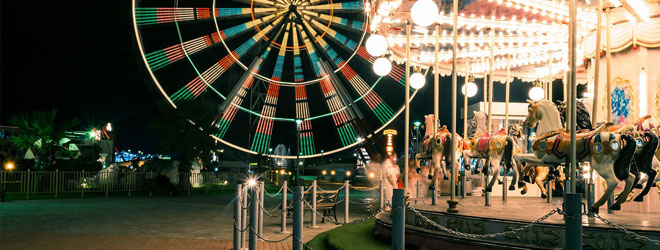 state fair image showing merry-go-round and ferris wheel in the background
